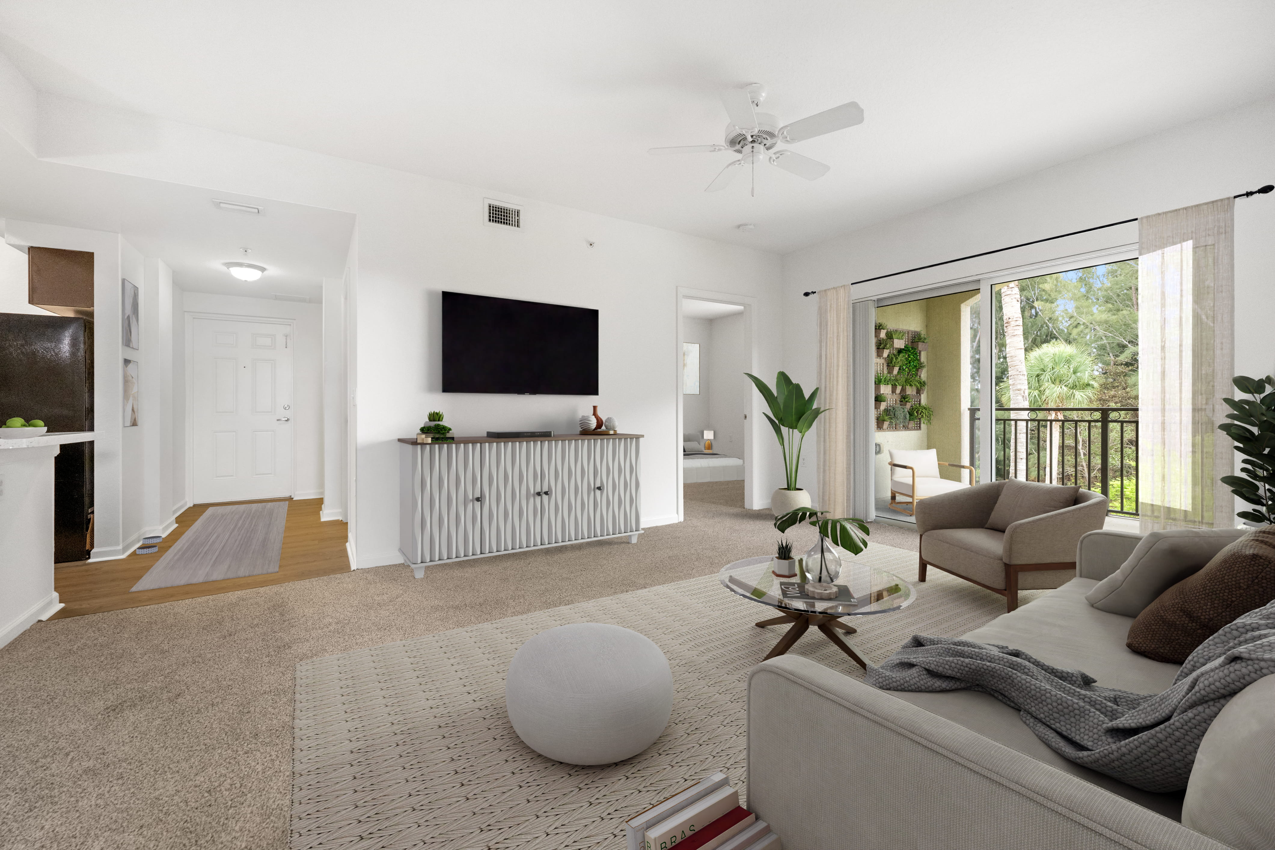 A living room with a grey couch, a white rug, and a white ceiling fan.
